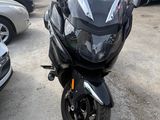 a black motorcycle parked in a parking lot next to other cars
