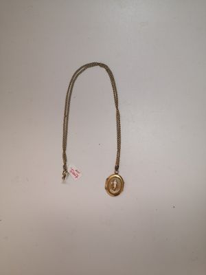 un gros plan d'un collier posé sur une surface blanche, avec une étiquette rouge