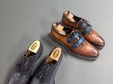 two pairs of men ' s shoes sitting on a table next to each other