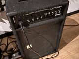 a black amp sitting on a wooden floor next to a keyboard