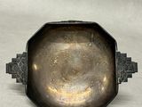 an antique silver plate with a decorative design on it