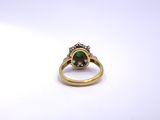 a close up of a gold ring with a green stone