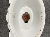 underside view of a white porcelain vase with a rusted lid