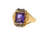 un gros plan d'une bague ornée d'une pierre violette entourée de diamants noirs