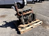 un petit moteur posé sur une palette dans le parking