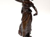 an antique bronze statue of a woman holding a flower