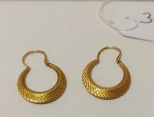 deux paires de boucles d'oreilles en or posées sur une surface blanche, avec une étiquette de prix
