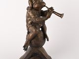 an image of a bronze statue of a man playing a trumpet