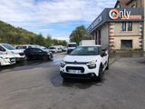 La voiture blanche est garée devant un immeuble devant lequel sont garées d'autres voitures.