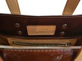 the inside of a brown and tan purse with a leather handle