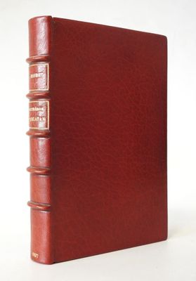 un livre en cuir rouge sur lequel sont posés trois autres livres