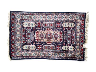 un tapis bleu et rouge à franges sur fond blanc