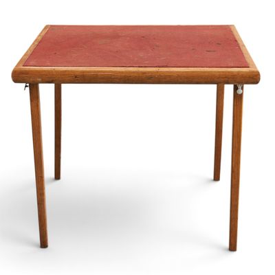 une petite table avec un plateau rouge et des pieds en bois