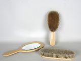 a wooden brush and a mirror on a table