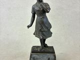 bronze statue of a young girl holding a flower in her hand
