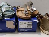 several pairs of sandals are sitting on top of boxes on a table