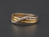 gros plan d'une bague en or et diamants sur une surface noire
