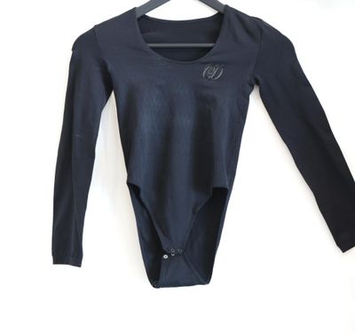 a black bodysuit hanging on a hanger on a white wall