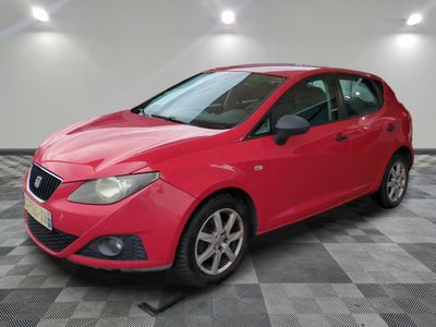 une voiture rouge garée dans un garage au sol en damier