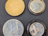 four different types of tins are shown on a black surface