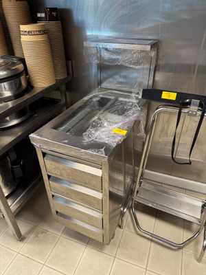 une table en acier inoxydable avec un plateau en verre dans une cuisine
