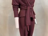 the mannequin is wearing a burgundy colored outfit with a belt