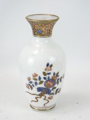 un vase blanc orné de fleurs bleues et roses