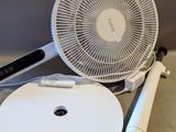 un éventail blanc posé sur une table, à côté d'une assiette blanche