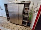 un meuble en acier inoxydable dans une cuisine, avec une porte rouge