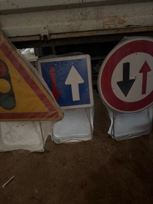 de nombreux panneaux de toutes sortes posés par terre à côté d'un camion