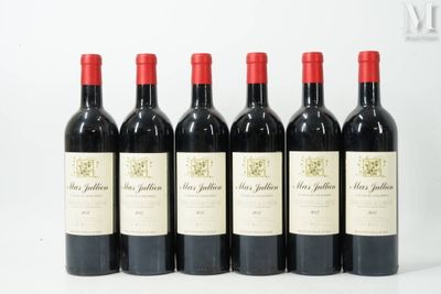 six bottles of red wine lined up in a row on a table