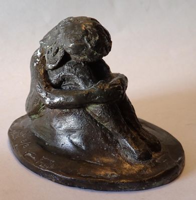 une statue représentant un chien assis sur un rocher