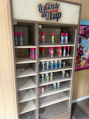a display case with several bottles of soda in it