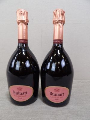 deux bouteilles de vin posées sur une table l'une à côté de l'autre