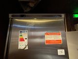 an image of a stainless steel refrigerator in a dark room