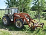 a small tractor that is parked in the grass