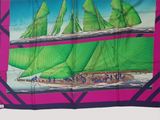 a green sailboat with green sails on a pink background