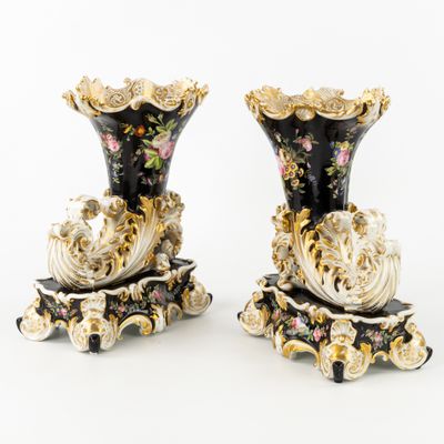 une paire de vases noirs et dorés ornés de motifs floraux