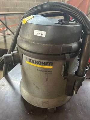 un gros plan d'un aspirateur posé sur une table, muni d'un tuyau