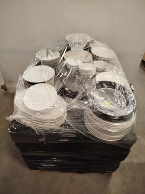 de nombreuses assiettes et bols posés sur une palette dans un entrepôt