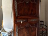 une armoire en bois dans un coin de la pièce, à côté d'une chaise