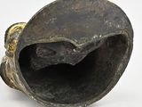 an old bronze vase with a hole in the middle of it