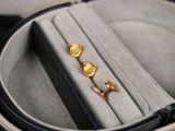 deux paires de boucles d'oreilles dans un écrin posé sur une table