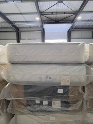 many mattresses stacked on top of each other in a warehouse