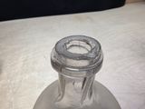 a glass bottle with a ring on it sitting on a table