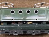 a green train engine sitting on top of a brown carpet