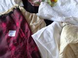 a pile of clothes on a bed with a tag on it