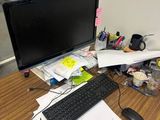 un bureau sur lequel se trouvent un ordinateur, un clavier, une souris et des papiers