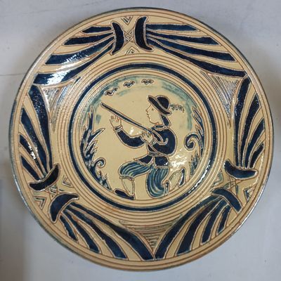 une assiette bleue et jaune sur laquelle est représenté un oiseau