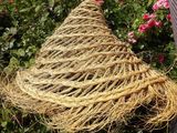 a straw hat on top of a pole in a garden